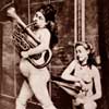 In case the image is too small, this is a photo of a gal using a bellows to inflate (via the butthole) her horn-tooting friend.